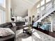 Inviting living room with vaulted ceilings, plush seating, and seamless transition to the modern kitchen at 6561 Ocaso Dr, Castle Pines, CO 80108