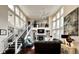 Bright living room features a fireplace, soaring ceilings, and abundant natural light from large windows at 6561 Ocaso Dr, Castle Pines, CO 80108