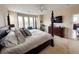 Spacious main bedroom with a four-poster bed, a fireplace, a ceiling fan, and plenty of natural light at 6561 Ocaso Dr, Castle Pines, CO 80108