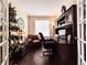 Inviting home office with hardwood floors, a large desk, a leather chair, and built-in bookshelves at 6561 Ocaso Dr, Castle Pines, CO 80108