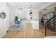 Open concept dining area with modern light fixture, natural light, and wooden floors, adjacent to the kitchen island at 3927 Inca St, Denver, CO 80211