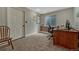 Carpeted office with a wooden desk, chair, and natural light from the window at 19346 E Prentice Ln, Centennial, CO 80015