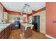 Functional kitchen featuring an island, black appliances, wood cabinets, and pot rack at 19346 E Prentice Ln, Centennial, CO 80015