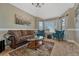 Comfortable living room with a brown sofa, teal armchairs, bay windows and neutral walls at 19346 E Prentice Ln, Centennial, CO 80015
