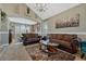 Cozy living room featuring plush brown sofas, a stylish rug, and a vaulted ceiling with a chandelier at 19346 E Prentice Ln, Centennial, CO 80015