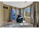 Comfortable sitting room with natural light and blue accent chair at 19346 E Prentice Ln, Centennial, CO 80015