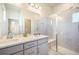 Well-lit bathroom with a dual sink vanity and modern glass shower enclosure at 6940 Clay St, Denver, CO 80221