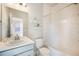 Well-lit bathroom with a single sink vanity, toilet, and shower-tub combo at 6940 Clay St, Denver, CO 80221
