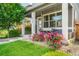 Close-up of a charming front porch with a swing and vibrant flower bushes in a beautifully landscaped yard at 6940 Clay St, Denver, CO 80221