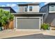 Exterior view of a gray two-car garage, set in a row of similar homes on a sunny day at 6940 Clay St, Denver, CO 80221