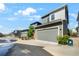 Exterior view of a gray two-car garage, set in a row of similar homes on a sunny day at 6940 Clay St, Denver, CO 80221