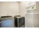 Laundry room featuring modern washer and dryer with a shelf and storage above at 6940 Clay St, Denver, CO 80221