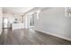 Bright, open-concept living room with hardwood floors, white walls, and modern kitchen with stainless appliances at 6940 Clay St, Denver, CO 80221