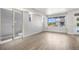 Bright living room features sliding glass doors, hardwood floors, white walls, and natural light at 6940 Clay St, Denver, CO 80221