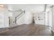 Bright, open-concept living room with hardwood floors, white walls, staircase, and modern kitchen at 6940 Clay St, Denver, CO 80221