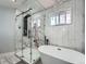 Spa-like bathroom features a modern shower, soaking tub, and elegant fixtures at 8007 S Dover St, Littleton, CO 80128