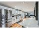 Modern kitchen with stainless appliances, white cabinets, hardwood floors and ample counter space at 8007 S Dover St, Littleton, CO 80128