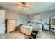 Bright main bedroom features wood floors, ceiling fan, and dresser for ample storage at 8007 S Dover St, Littleton, CO 80128