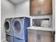 Laundry room with blue washer and dryer, sink and cabinets at 359 Castlemaine Ct, Castle Rock, CO 80104