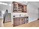 Custom wet bar with glass-front cabinets, quartz countertops, and wine cooler at 359 Castlemaine Ct, Castle Rock, CO 80104