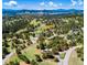Mountainous aerial view showcases the property nestled within a lush, rolling, wooded landscape at 21868 Mountsfield Dr, Golden, CO 80401