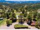 Aerial shot of the property shows solar panels, a parking area, and mature trees at 21868 Mountsfield Dr, Golden, CO 80401