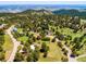 Scenic aerial view showcasing the property nestled among trees with distant mountain views in the background at 21868 Mountsfield Dr, Golden, CO 80401