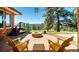 Spacious brick patio with comfortable seating, fire pit and scenic views of surrounding trees and mountains at 21868 Mountsfield Dr, Golden, CO 80401