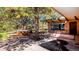 Picturesque backyard featuring a relaxing hot tub, mature trees, a bench and stone patio area at 21868 Mountsfield Dr, Golden, CO 80401