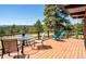 Inviting deck with views, features a glass table, chairs, and a wood railing at 21868 Mountsfield Dr, Golden, CO 80401