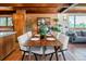 Dining room features wood dining table, tile floor, brick wall accents, and nearby living area at 21868 Mountsfield Dr, Golden, CO 80401