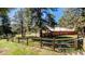 Charming brick home nestled among mature trees with a wooden fence and lush green lawn at 21868 Mountsfield Dr, Golden, CO 80401
