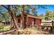 Two-car garage with a brick exterior, nestled among mature trees and a charming landscape at 21868 Mountsfield Dr, Golden, CO 80401