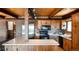 Spacious kitchen features brick walls, stainless steel refrigerator, wood cabinetry, and a brick-and-wood ceiling at 21868 Mountsfield Dr, Golden, CO 80401