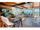 Bright living area featuring wood beam ceiling, tile floors, and large windows offering picturesque mountain views at 21868 Mountsfield Dr, Golden, CO 80401