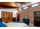 Bedroom with brick wall, exposed beam ceiling, closet and modern dresser at 21868 Mountsfield Dr, Golden, CO 80401