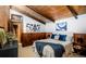 Cozy bedroom with wood paneling, exposed beam ceiling and stylish decor at 21868 Mountsfield Dr, Golden, CO 80401