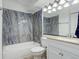Stylish bathroom with bathtub, tile surround, modern vanity, and updated lighting fixture at 4400 S Quebec St # 105K, Denver, CO 80237