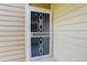 The front door is decorated with an ornate security screen door, with beige siding around it at 4400 S Quebec St # 105K, Denver, CO 80237
