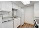 Bright kitchen with white cabinets, modern appliances, neutral countertops, and luxury vinyl flooring at 4400 S Quebec St # 105K, Denver, CO 80237