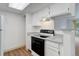 Modern kitchen with white cabinets, stainless steel appliances, bar and luxury vinyl flooring at 4400 S Quebec St # 105K, Denver, CO 80237