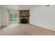 Bright living room with a stone fireplace, sliding glass door, and neutral carpet at 4400 S Quebec St # 105K, Denver, CO 80237