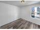 Cozy bedroom with wood floors and a large window providing natural light at 4940 Akron St, Denver, CO 80238