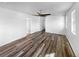 Spacious bedroom with closet door and ceiling fan plus gray wood-style flooring at 4940 Akron St, Denver, CO 80238
