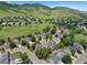 Expansive aerial view of a neighborhood nestled amongst rolling hills and open green spaces under a clear blue sky at 18 Blue Sage, Littleton, CO 80127