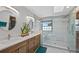 Modern bathroom with double sinks, a glass-enclosed shower, and a window at 18 Blue Sage, Littleton, CO 80127