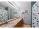 Bright bathroom features a long vanity with double sinks and a floral shower curtain at 18 Blue Sage, Littleton, CO 80127