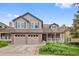 Inviting two-story home with brick accents, a covered porch, and an attached two-car garage at 18 Blue Sage, Littleton, CO 80127