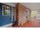 Cozy covered front porch with red wood floors, brick siding, and traditional detailing at 18 Blue Sage, Littleton, CO 80127