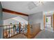 Upstairs hallway with wood railing overlooking living room at 18 Blue Sage, Littleton, CO 80127